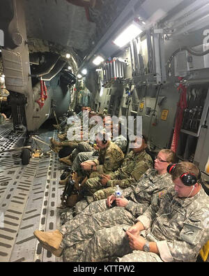 New York Army National Guard Soldaten der dritten Bataillon 142 Assault Helicopter Bataillon an Bord einer C-17 von der New York Air National Guard geflogen auf dem Weg von Puerto Rico nach der Bereitstellung von Ronknonkoma, NEW YORK, Sept. 28, 2017. Das Bataillon gesendet 60 Soldaten und 4 UH-60 s zu den Puerto Rico National Guard assit bei der Reaktion auf die Folgen des Hurrikans Maria. Stockfoto