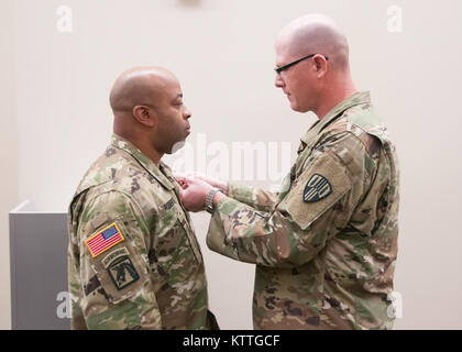 Oberst Stephen M. Bousquet, der Kommandant der 369. sustainment Brigade, präsentiert die Meritorius Service Medal, Maj Everett Roberts während einer Zeremonie im Camp Smith, NY, 22. Oktober 2017. Maj. Roberts erhielt die Auszeichnung für seine Zeit als Executive Officer der 101 Signal Battalion. Stockfoto