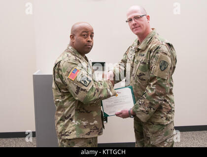 Oberst Stephen M. Bousquet, der Kommandant der 369. sustainment Brigade, präsentiert die Meritorius Service Medal, Maj Everett Roberts während einer Zeremonie im Camp Smith, NY, 22. Oktober 2017. Maj. Roberts erhielt die Auszeichnung für seine Zeit als Executive Officer der 101 Signal Battalion. Stockfoto