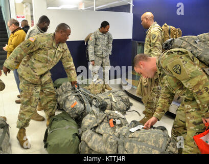 JFK Airport, Queens, NY - Am 15. Dezember 2017, mehr als 30 Soldaten aus der New York Army National Guard 442nd Military Police Company Home aus ihrer Mission in Puerto Rico, wo sie seit 2. Oktober 2017 eingesetzt wurden zurückgegeben. Während ihrem Einsatz in Puerto Rico die Soldaten Sicherheit und humanitäre Hilfe zur Unterstützung des Hurrikans Hilfsmaßnahmen. Nach Wetter verzögert in New York, mehrere Soldaten in JFK International Airport am Abend landete, und dann Ihren Bus, der Sie zuerst Ihre Waffenkammer in Jamaica, NY nahm und dann zum Camp Smith Training Website in Zusammenarbeit an Bord Stockfoto