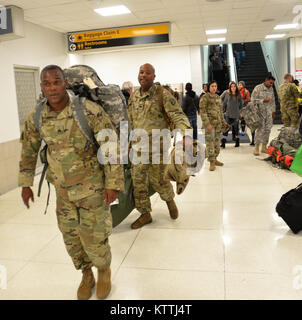 JFK Airport, Queens, NY - Am 15. Dezember 2017, mehr als 30 Soldaten aus der New York Army National Guard 442nd Military Police Company Home aus ihrer Mission in Puerto Rico, wo sie seit 2. Oktober 2017 eingesetzt wurden zurückgegeben. Während ihrem Einsatz in Puerto Rico die Soldaten Sicherheit und humanitäre Hilfe zur Unterstützung des Hurrikans Hilfsmaßnahmen. Nach Wetter verzögert in New York, mehrere Soldaten in JFK International Airport am Abend landete, und dann Ihren Bus, der Sie zuerst Ihre Waffenkammer in Jamaica, NY nahm und dann zum Camp Smith Training Website in Zusammenarbeit an Bord Stockfoto