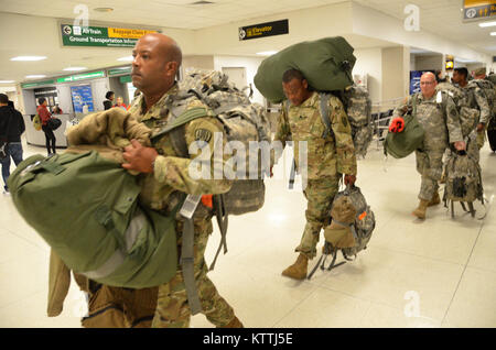 JFK Airport, Queens, NY - Am 15. Dezember 2017, mehr als 30 Soldaten aus der New York Army National Guard 442nd Military Police Company Home aus ihrer Mission in Puerto Rico, wo sie seit 2. Oktober 2017 eingesetzt wurden zurückgegeben. Während ihrem Einsatz in Puerto Rico die Soldaten Sicherheit und humanitäre Hilfe zur Unterstützung des Hurrikans Hilfsmaßnahmen. Nach Wetter verzögert in New York, mehrere Soldaten in JFK International Airport am Abend landete, und dann Ihren Bus, der Sie zuerst Ihre Waffenkammer in Jamaica, NY nahm und dann zum Camp Smith Training Website in Zusammenarbeit an Bord Stockfoto