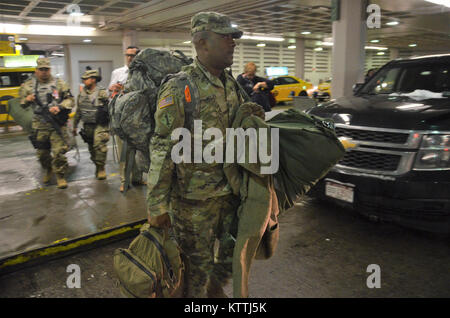 JFK Airport, Queens, NY - Am 15. Dezember 2017, mehr als 30 Soldaten aus der New York Army National Guard 442nd Military Police Company Home aus ihrer Mission in Puerto Rico, wo sie seit 2. Oktober 2017 eingesetzt wurden zurückgegeben. Während ihrem Einsatz in Puerto Rico die Soldaten Sicherheit und humanitäre Hilfe zur Unterstützung des Hurrikans Hilfsmaßnahmen. Nach Wetter verzögert in New York, mehrere Soldaten in JFK International Airport am Abend landete, und dann Ihren Bus, der Sie zuerst Ihre Waffenkammer in Jamaica, NY nahm und dann zum Camp Smith Training Website in Zusammenarbeit an Bord Stockfoto