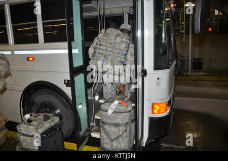 JFK Airport, Queens, NY - Am 15. Dezember 2017, mehr als 30 Soldaten aus der New York Army National Guard 442nd Military Police Company Home aus ihrer Mission in Puerto Rico, wo sie seit 2. Oktober 2017 eingesetzt wurden zurückgegeben. Während ihrem Einsatz in Puerto Rico die Soldaten Sicherheit und humanitäre Hilfe zur Unterstützung des Hurrikans Hilfsmaßnahmen. Nach Wetter verzögert in New York, mehrere Soldaten in JFK International Airport am Abend landete, und dann Ihren Bus, der Sie zuerst Ihre Waffenkammer in Jamaica, NY nahm und dann zum Camp Smith Training Website in Zusammenarbeit an Bord Stockfoto