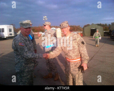 FLOYD BENNETT FIELD -- Kol. Ray Schilde, Direktor des Joint Staff für das New York National Guard dank Sgt. Jackson von der Pennsylvania National Guard für seine ausgezeichnete Arbeit bei der Regierung Fahrzeug tanken Punkt an Floyd Bennett Field betrieben wird. Jackson war bei der Herstellung der tanken Mission mit Luft und Army National Guard und zivilen Anlagen beteiligt. Seine Fähigkeit, um es herauszufinden erlaubt die National Guard bulk Kraftstoff aus kommerziellen DLA Tanker zu nehmen und es in unsere Tanken vermögen. Er hilft auch mehrere National Guard Vermögenswerte zu kommerziellen unverbleites Retail refuelers konvertieren. Stockfoto