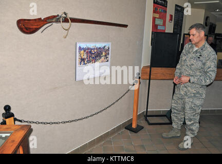 Oberst John balbierer, stellvertretender Kommandeur der 174 Angriff Wing, New York Air National Guard, Studien die neueste Ergänzung der Staat New York Joint Force Headquarters lobby Dez. 13, 2012. Die matchlock Musket ist eine exakte Nachbildung des Originals 1636 Newtowne Muskete vom Massachusetts Milizen, nachdem die Kolonie die erste Charter am Dez. 13, 1636 offiziell zur Gründung der Miliz in Kraft gesetzt. Als Nummer 11 der 375, die Muskete wurde mit den großzügigen Spenden von New York Armee und Air National Guard Senior NCO's gekauft und für die Anzeige in der New York Kapitel der EANGUS Dez. 13, 2012 vorgestellt. Stockfoto