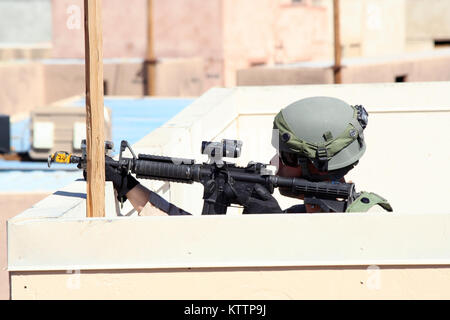 NATIONAL TRAINING CENTER, FORT IRWIN, Kalifornien - ein Soldat von 11 Armored Cavalry Regiment, Rollenspiel als afghanische Armee Soldat, bietet overwatch Für die Manöver der New York Army National Guard Soldaten aus C Troop, 2.Staffel, 101 Kavallerie durch ein mock Dorf hier Okt. 9. Der NTC-ausbildung Rotation, bis Ende Oktober, bietet Soldaten aus dem 27 Infantry Brigade Combat Team mit einem realistischen, anspruchsvolle Ausbildung. Die Ausübung betont Führer, Soldaten und Angestellten in einer simulierten Umgebung bekämpfen. Die Einheit, in Buffalo, N.Y., ist Teil der 27 Infanterie Br Stockfoto