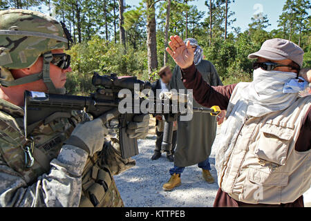 Delaware, Ohio, native Cpl. William Howard von Bravo Unternehmen 1-148 Infanterie Regiment, 37th Infantry Brigade Combat Team, Ohio National Guard, die eskalierende Gewalt aus Demonstranten auf Station außerhalb seines Bataillons Forward Operating Base im Lager Shelby Joint Forces Training Center, Fräulein, Oktober 21, 2011, während einer Übung der Feuerwehr für den geplanten Einsatz in Afghanistan zur Unterstützung der Operation Enduring Freedom zu bereiten. (Ohio National Guard Foto: Staff Sgt. Sean Mathis) (freigegeben) Stockfoto