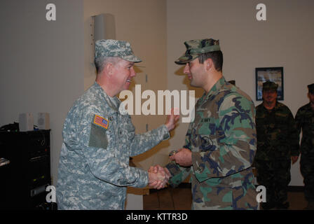 SCOTIA - New York Army National Guard Brig. Gen. Michael Swezey durch Mitglieder der New York Naval Miliz, die auch mit der United States Navy Reserve für ihren Service während die staatliche Reaktion auf Tropische Sturm Irene während einer Zeremonie an der Scotia Streitkräfte finden Mitte am Sonntag, Dez. 4. Swezey, der Joint Task Force Irene während des Sturms Antwort geboten hatte, stellte der Staat New York den humanitären Dienst Medaillen zu 40 Naval Reserve Mitglieder während der Sonntag morgen Event. Stockfoto