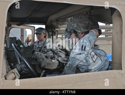 12601-A-YK 528-008 Guantanamo Bay auf Kuba (Juni 1, 201) - New York Army National Guard Citizen-Soldiers der 107 Military Police Company eine fast einjährige Bereitstellung abgeschlossen gemeinsame Aufgabe Force-Guantanamo in diesem Monat. Spc. Nicole Davis, vorne, passt ihr Kevlar Helm vor der Fahrt als SPC. Francine Del Valle in den Humvee. (U.S. Armee Foto von Sgt. 1. Klasse Kryn S. Westhoven / freigegeben) Stockfoto