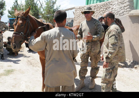 Sgt. 1. Klasse Pete Padgett, schwere Waffen Firma Mentor für die 5. Zone afghanische Grenzpolizei Sicherheit Kraft Hilfe team zu der 37th Infantry Brigade Combat Team zugewiesen, spricht mit einem lokalen Bauern über sein Pferd während der letzten Mission auf den 5 Kandak in Khawajah Bahawuddin, Provinz Badakhshan, Afghanistan, 27. Juni 2012. Padgett, die Pferde zurück besitzt in seinem Haus in Eatonville, Washington, geholfen, die 5 Kandak Soldaten, um zu entscheiden, welche Pferde von lokalen Bauern für berittene Patrouille des Kandak der tadschikischen Grenze setzen zu kaufen. (37 IBCT Foto von Sgt. Kimberly Lamm) (freigegeben) Stockfoto