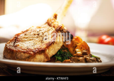 Gebackene Schnitzel oder Kotelett mit Pilzsauce und Kartoffeln mit Spinat Stockfoto