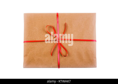 Geschenk in Geschenkpapier mit roter Schleife auf weißem Hintergrund gebunden, Top View close-up Stockfoto