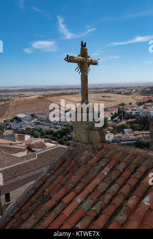 Alten verwitterten Steinernen Kreuz sitzt zwischen den Twin Towers der Iglesia de San Francisco Javier in Caceres, Spanien Stockfoto