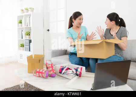 Schöne hübsche weibliche Freunde auf jedes andere Gefühl überrascht, wenn Sie online einkaufen Unternehmen besondere Geschenk Paket Box zu Hause empfangen. Stockfoto