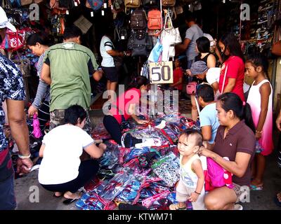 ANTIPOLO CITY, Philippinen - Dezember 23, 2017: Kunden suchen und wählen Sie unter den verschiedenen Kinder Schuhe in provisorischen Lagern durch einen Bürgersteig. Stockfoto