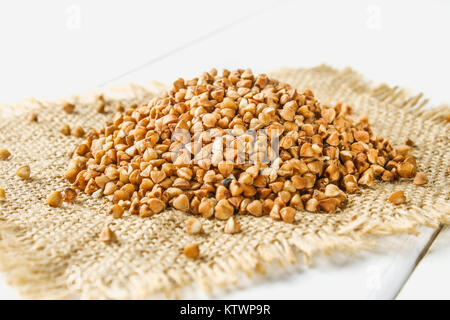 Raw Buchweizen auf einem Sack auf einen hölzernen Tisch. Gesunde Ernährung Essen Stockfoto