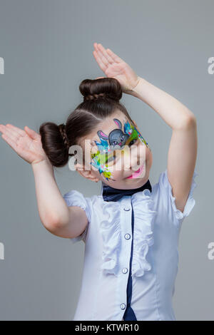 Ein kleines Mädchen von asiatischen Aussehen mit einem gemalten lyom. Aqua Make-up Schminken. Stockfoto