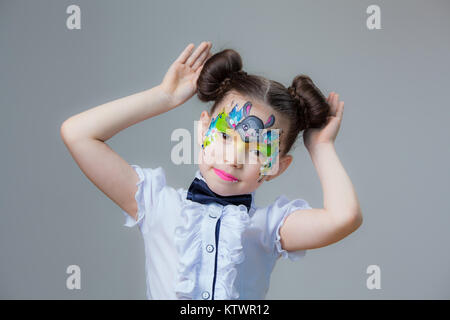 Ein kleines Mädchen von asiatischen Aussehen mit einem gemalten lyom. Aqua Make-up Schminken. Stockfoto