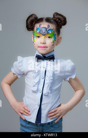 Ein kleines Mädchen von asiatischen Aussehen mit einem gemalten lyom. Aqua Make-up Schminken. Stockfoto