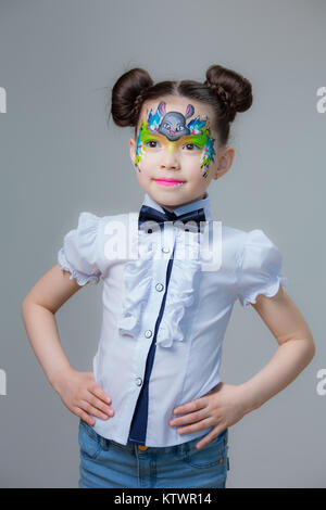 Ein kleines Mädchen von asiatischen Aussehen mit einem gemalten lyom. Aqua Make-up Schminken. Stockfoto