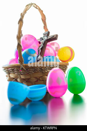 Ein brauner Korb ist voll von verzierten Ostereier. Ein Kruzifix gehört zu den Eier in den Korb. Im Stehen vor dem Korb sind drei dekorierten e Stockfoto