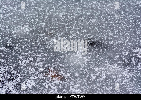 Blue White Ice im Schnee Flocken bedeckt. Stockfoto