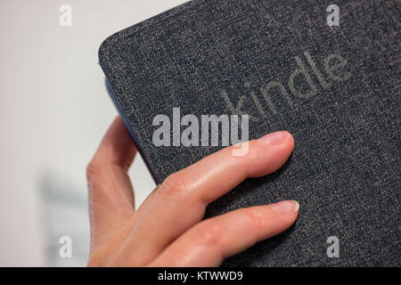 Frau Hand e-book reader (Amazon Kindle Paperwhite) in seiner Hand. Eine der am meisten Pappel Lesegeräte für ebooks. Stockfoto