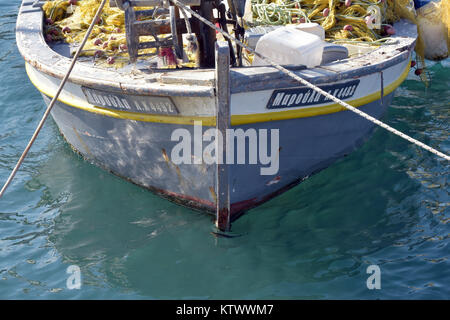 Die bögen oder vor einem griechischen Fischerboot in das klare Wasser des Ionischen Meeres an die Hafenmauer mit zwei Seilen gebunden. Korfu Schiffe im Hafen. Stockfoto