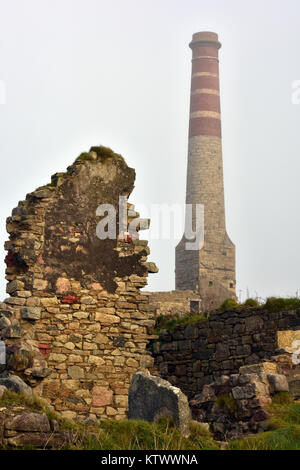 Die Ruinen einer Cornish Zinnmine Motor Haus mit den gemauerter Schornstein und zerstörten Überreste der ehemaligen Gebäude für historische Arbeiten erhalten Stockfoto