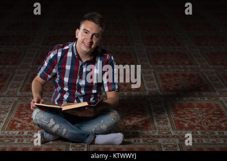 Bescheidenen muslimischer Mann liest den Koran In der Moschee Stockfoto