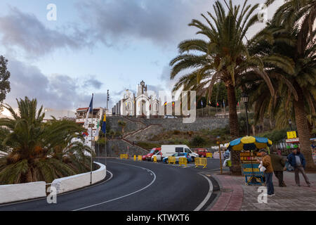 Santa Lucia, Gran Canaria in Spanien - Dezember 13, 2017: Straße mit Menschen und Autos, und die Kirche in den Rücken, auf den besonderen Tag der Fiesta für den Schutzheiligen, Santa Lucia Stockfoto