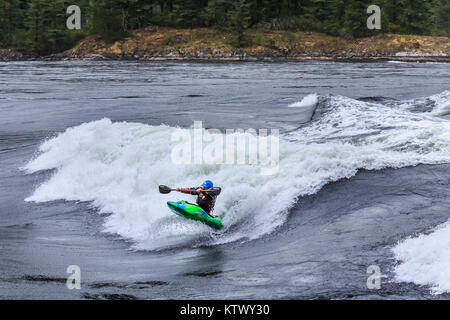 Mit einer Masse von Luftblasen unter Bug seines Kajak, einem Playboater hält seine Paddel wie er reitet auf dem Gesicht eines riesigen, schnelle Welle in Sechelt Rapids, BC. Stockfoto