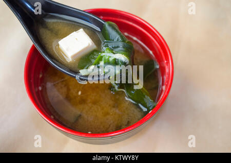 Japanische Miso Suppe mit Tofu und Algen. Ton Löffel Nahaufnahme mit einem tofu Stück Stockfoto