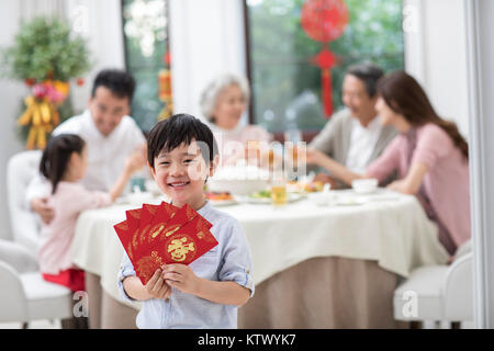 Happy little boy Holding viele rote Umschläge Stockfoto