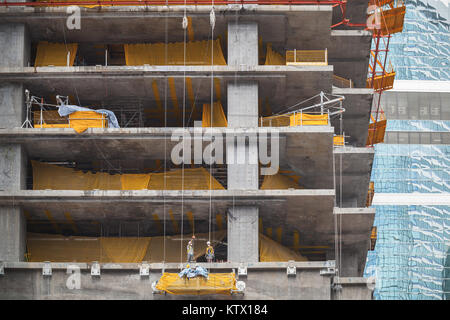 Modernes Gebäude im Bau ist, Betonböden. Chinesische Arbeiter sind auf der Ladestation Stockfoto