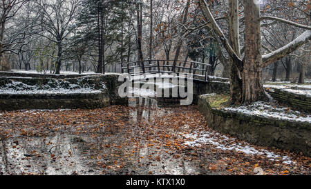 Belgrad, Serbien - hölzerne Fußgängerbrücke in Topcider Park bedeckt mit den ersten Schnee des Winters Stockfoto