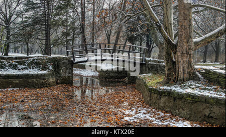 Belgrad, Serbien - hölzerne Fußgängerbrücke in Topcider Park bedeckt mit den ersten Schnee des Winters Stockfoto