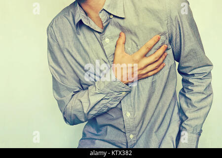 Nahaufnahme reife männliche schmerzhafte Brust. Chronische Herzinsuffizienz. Junger Mann mit Schmerzen in der Brust. Unternehmer im blauen Hemd mit Herzkrankheit. Herzinfarkt. Hype Stockfoto