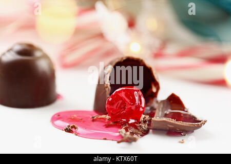 Schokolade Kirschen. Flache Tiefenschärfe mit selektiven Fokus auf gebissen Teil von candy Trüffel mit freiliegenden Kirsche. Stockfoto