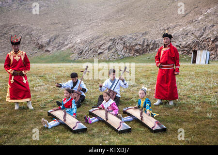 Jungs, Morin khuur (Saiteninstrument) (Pferd - Kopf - Violine) Während junge Mädchen spielen Yatga-Yatuga (Saiteninstrument), Bunkhan, Mongolei, Centr Stockfoto
