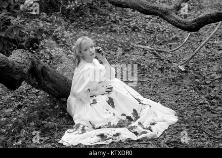 Schöne blonde Mädchen in einem weißen Kleid in voller Länge in der Landschaft Stockfoto
