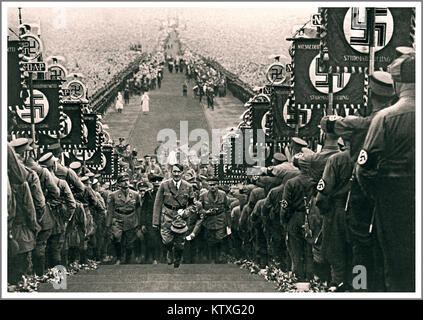 1930 Propaganda Bild von Adolf Hitler zu einer großen Nazi Party Rally am Bückeberg Niedersachsen Deutschland mit Sturmabteilung troopers Holding der nationalsozialistischen NSDAP Hakenkreuz symbolische Fahnen der Sturmabteilung (Sa), die als der ursprüngliche paramilitärischen Flügel der Nsdap. Es spielte eine bedeutende Rolle in der Adolf Hitler in den 1920er und 1930er Jahre. Stockfoto