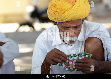 Portrait von hochrangigen indischen Mann mit Schnurrbart tragen gelbe Turban und spielen Kartenspiel in das Dorf in der Nähe von Pushkar, Rajasthan, Indien. Stockfoto