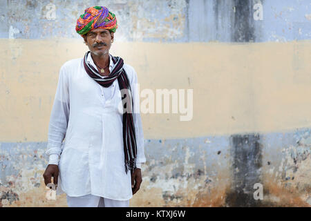 Porträt der alten indischen Mann mit Schnurrbart, grüne Augen in weißem Outfit mit einer bunten Turban und einen Schal, der in einem Dorf in der Nähe von Pushkar, Rajasthan, Indien. Stockfoto