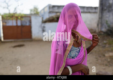 Porträt der jungen indischen Frau, tragen, Sari und einem rosa Schleier, ihr Gesicht in den Hof, Dorf in der Nähe von Pushkar, Rajasthan, Indien. Stockfoto