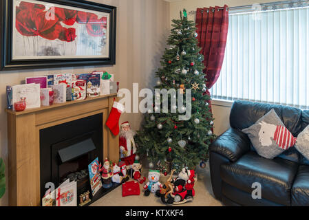 Ein modernes Wohnzimmer in Schottland in ein modern gestaltetes Haus mit Baum und Dekorationen ein Kamin mit Grußkarten und dekorative Spielzeug auf dem Boden ein Stockfoto