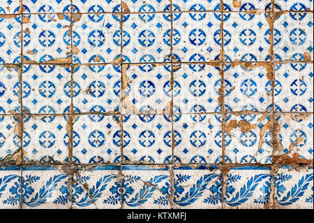 Alte, verwitterte, Portugiesisch Azulejo Kacheln mit kreisförmigen und florale Muster, die außenwände eines Gebäudes in Lissabon, Portugal, dekorieren. Stockfoto