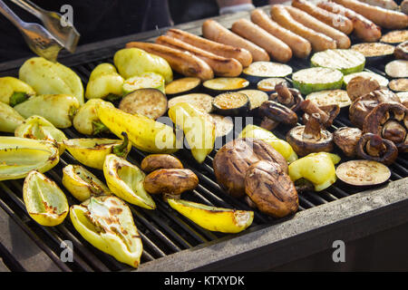 Sortierte lecker Gegrilltes Fleisch mit Gemüse auf dem Grill auf der Holzkohle. Würstchen, Steaks, Pfeffer, Pilze, Zucchini. Stockfoto