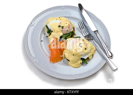 Eggs Benedict und geräucherter Lachs mit Sauce Hollandaise und verwelkte Spinat auf eine Englische Muffins serviert und mit Paprika bestäubt und gehackte Petersilie Stockfoto